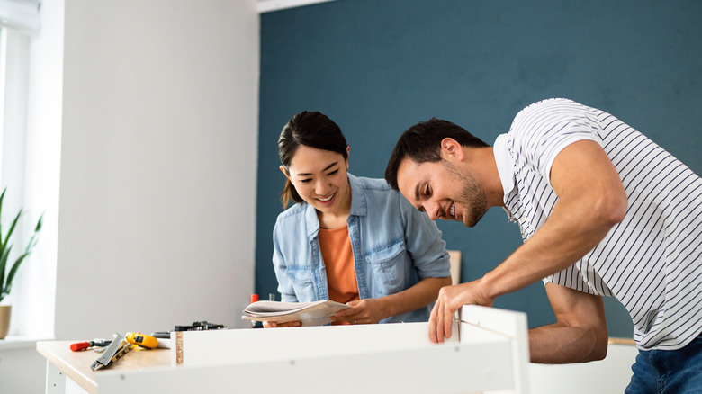 women and man assembling furniture