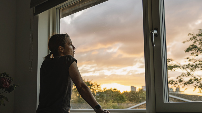 Woman looks out window