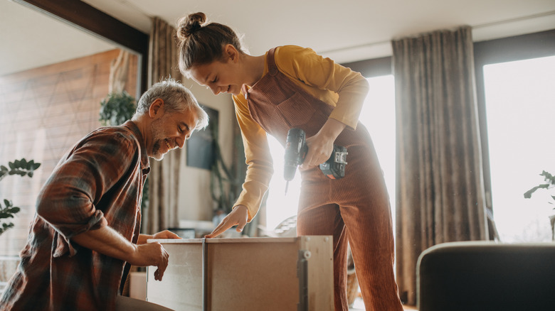 smiling couple building furniture