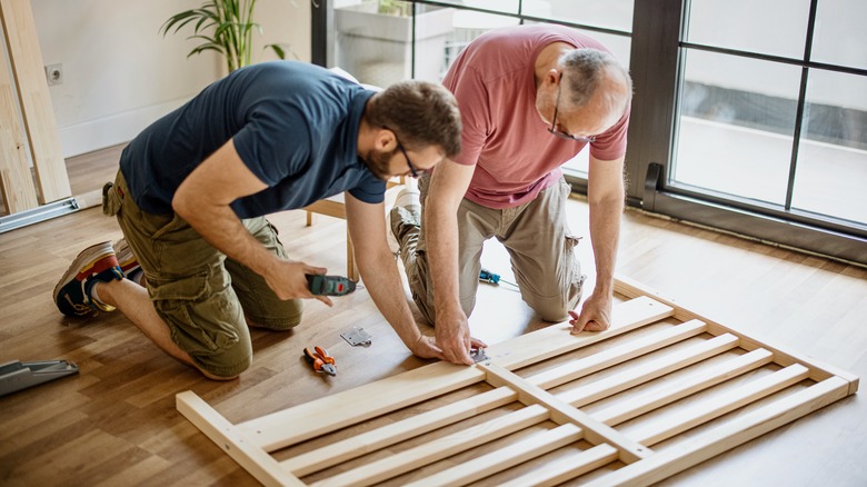 Two men building wood furniture 