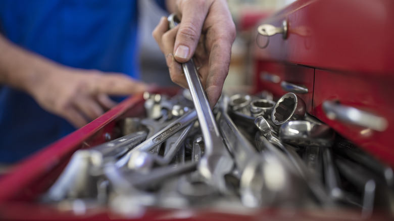 Hand grabbing tool from pile of disorganized tools