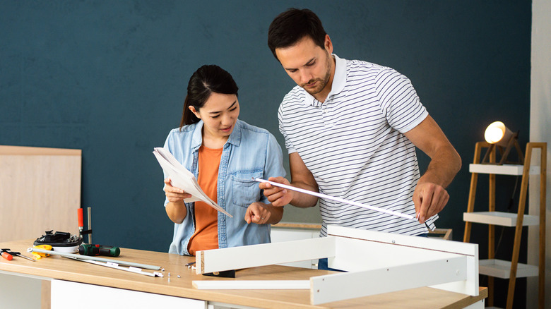 Couple putting cabinets together