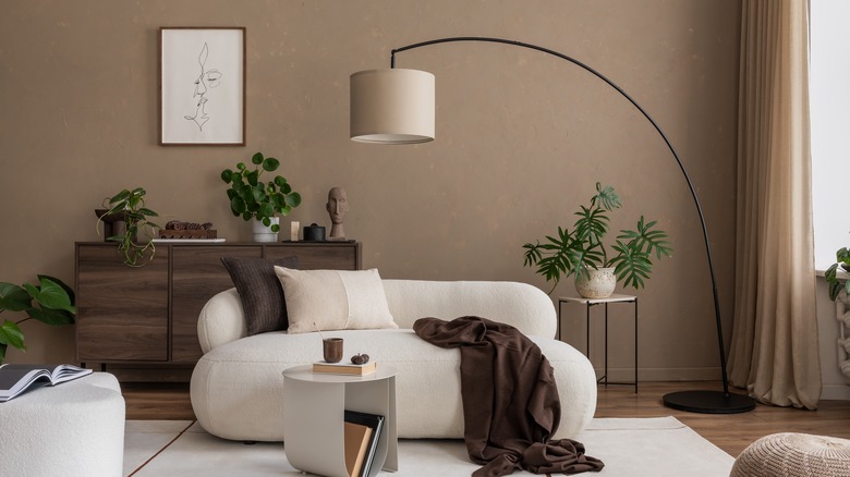 living room with arc floor lamp above couch