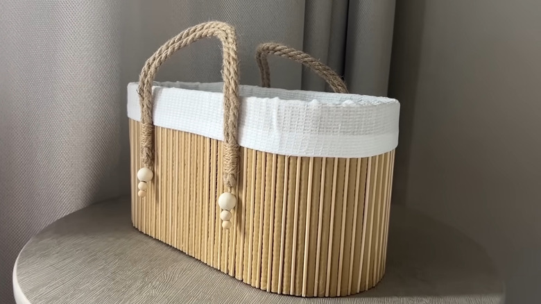 Completed basket made from cardboard, a bath mat, and cooking skewers