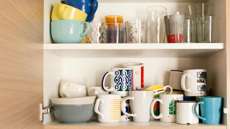 Shelf with multiple glasses and mugs stacked on each other.