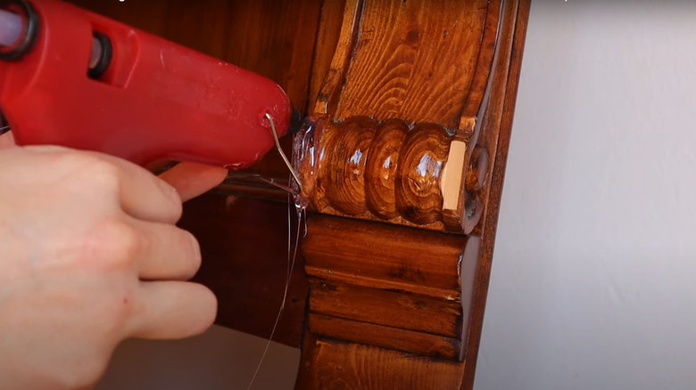 Applying hot glue on furniture