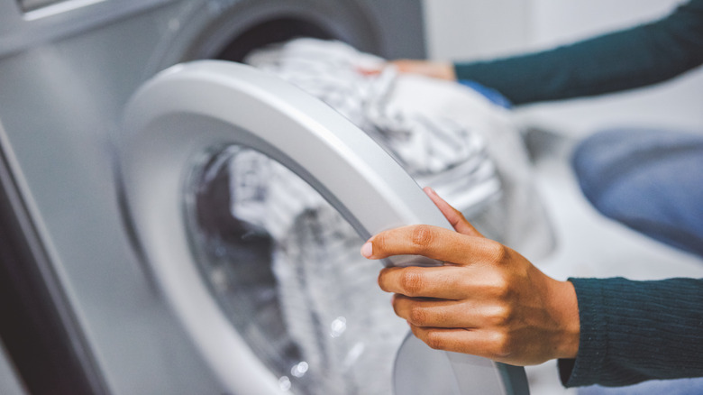 Person putting laundry in washer