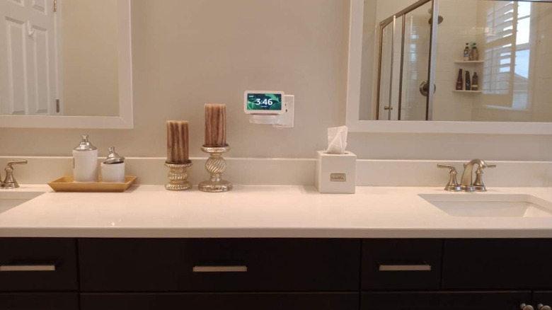 A cord-hiding outlet shelf above a bathroom vanity with two sinks.