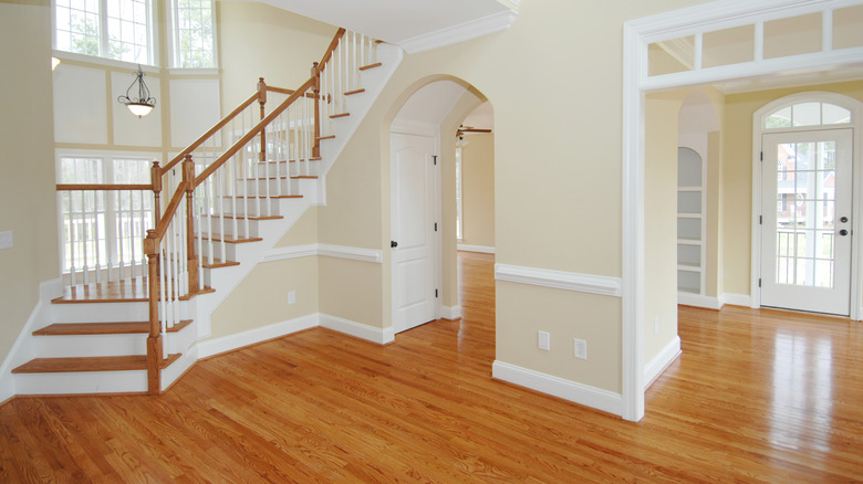 Interior with hardwood floors, white trim, stairway, and arched doorways