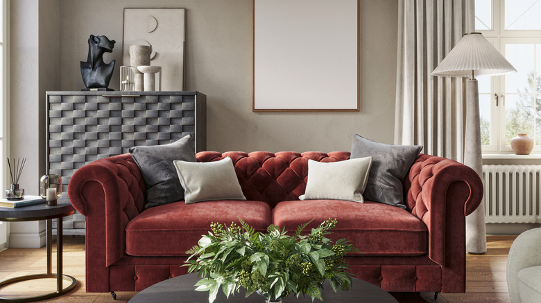 A modern living room with a red velvet couch.