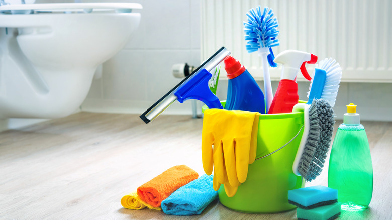 Bucket of cleaning tools on bathroom floor