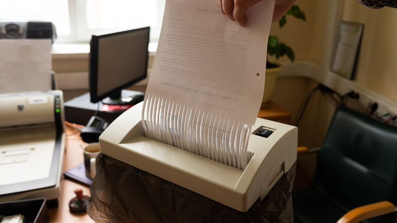 Person shredding paper in office