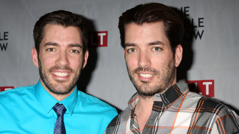 Property Brothers Jonathan and Andrew Scott post by a step and repeat.