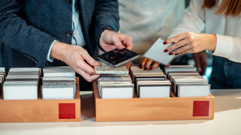 Two people looking at tile samples in wood boxes