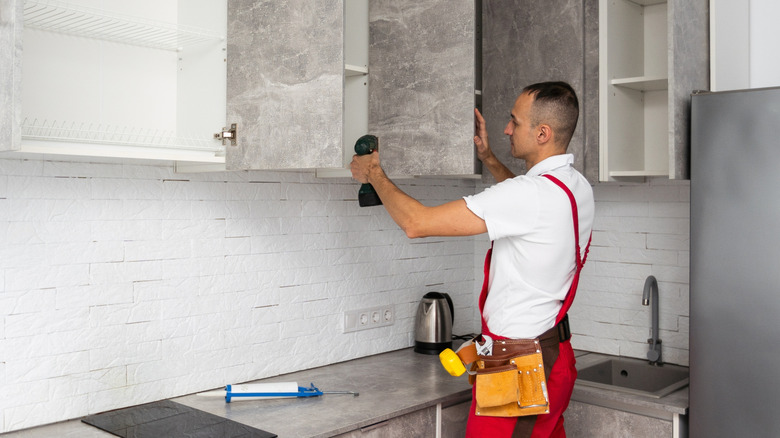 Man installing kitchen cabinets