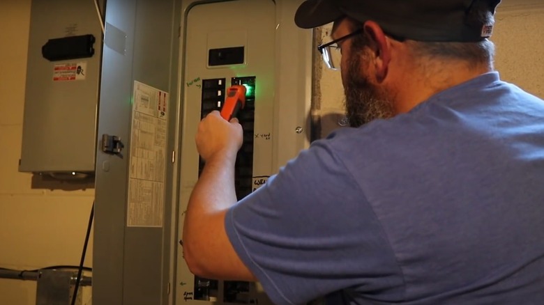 Man using a Klein circuit breaker testing tool