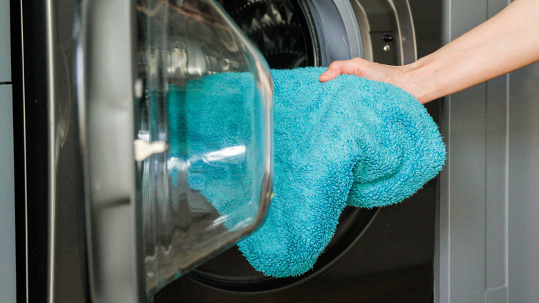 adding towel to washing machine