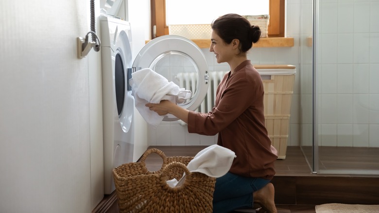 woman loading towels into dryer