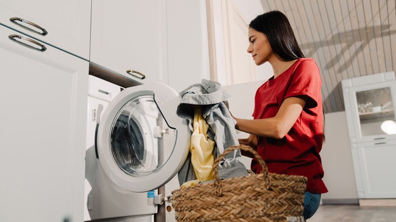 Woman loading laundry in machine