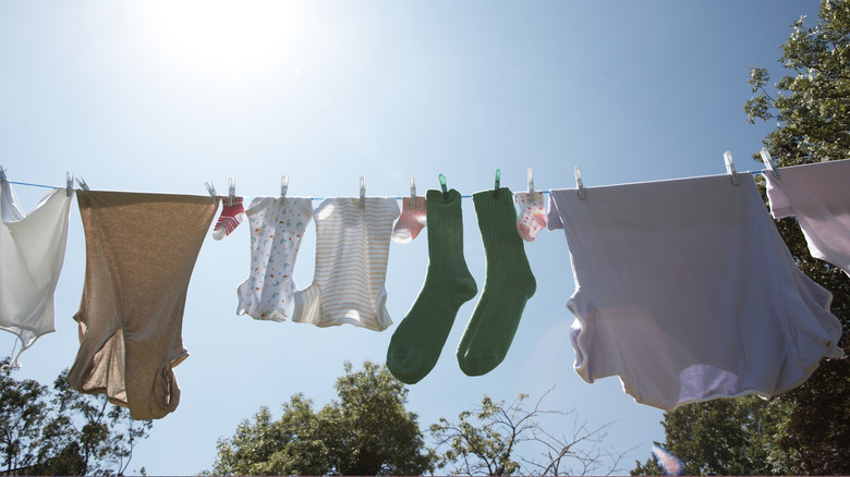 Hang drying laundry on outdoor line with clothespins