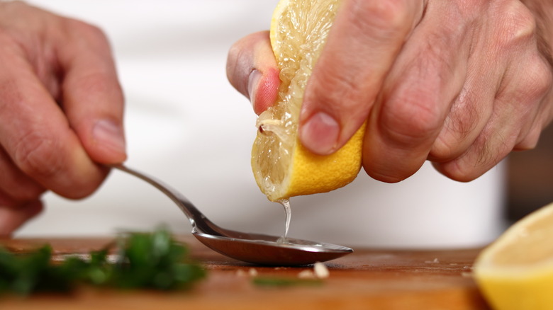 Hands squeezing a lemon