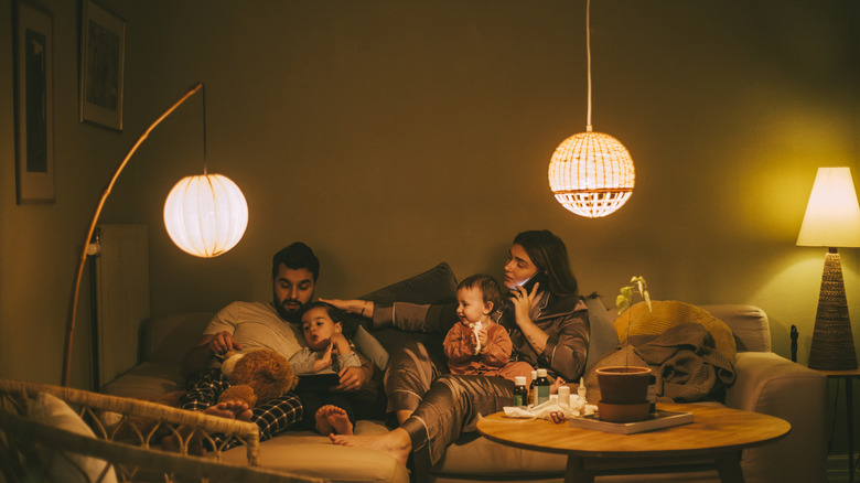 Family sitting in living room with multiple lamps