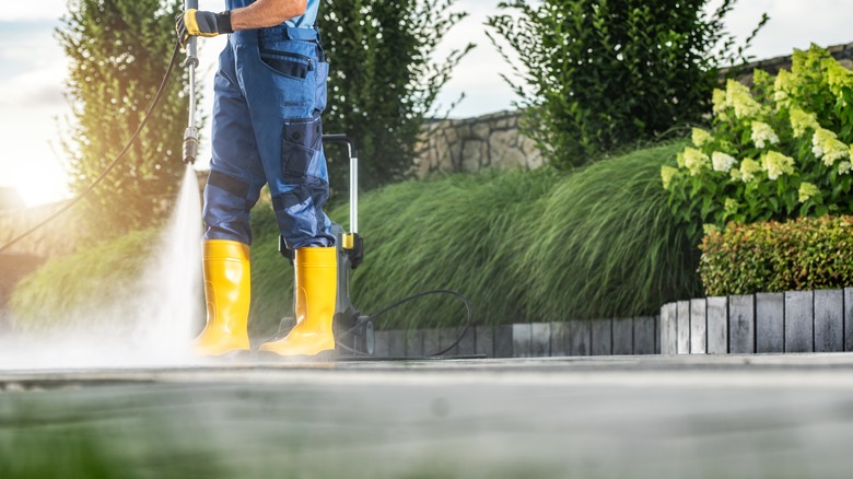 Man pressure washing a driveway