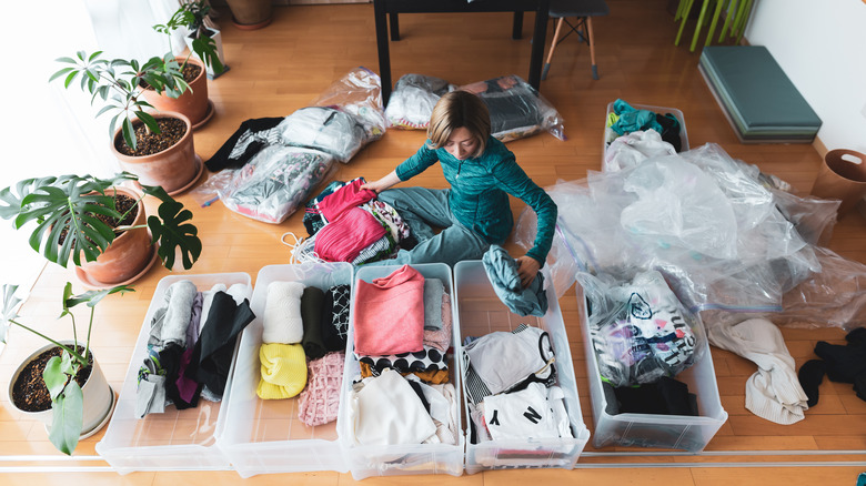 person organizing clothes in room