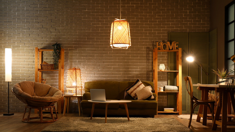 A living room with brick rear wall and stylish lighting fixtures