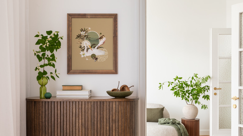 Framed art on wall with plant and books