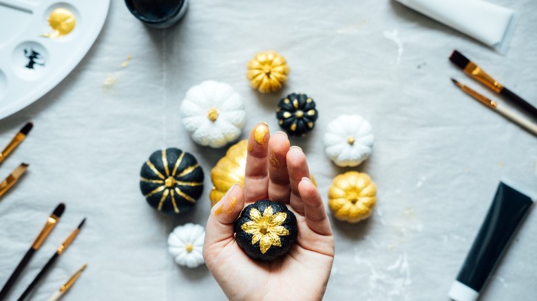 Pumpkins painted black, white, and gold