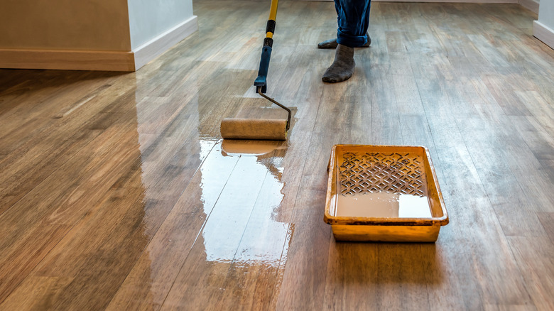 Applying sealer to wood floor