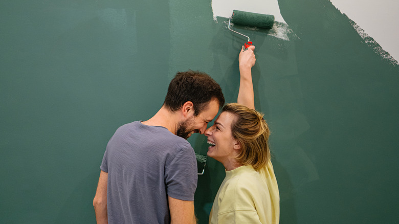 couple painting wall green