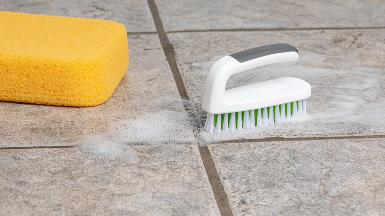 Scrub brush on kitchen tile floor grout