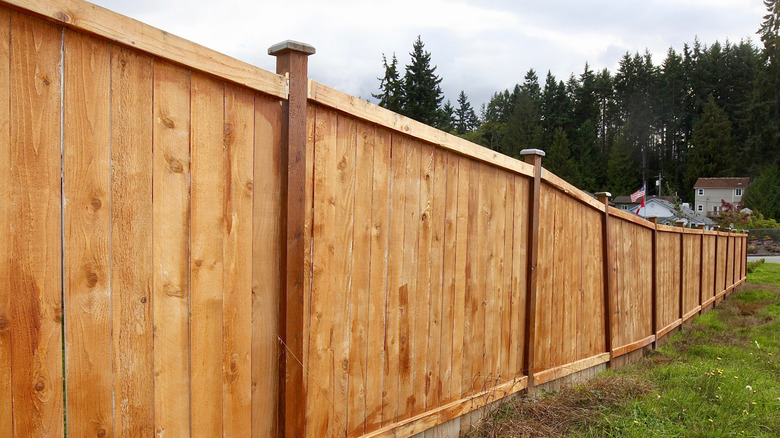 Long cedar fence on the edge of a property