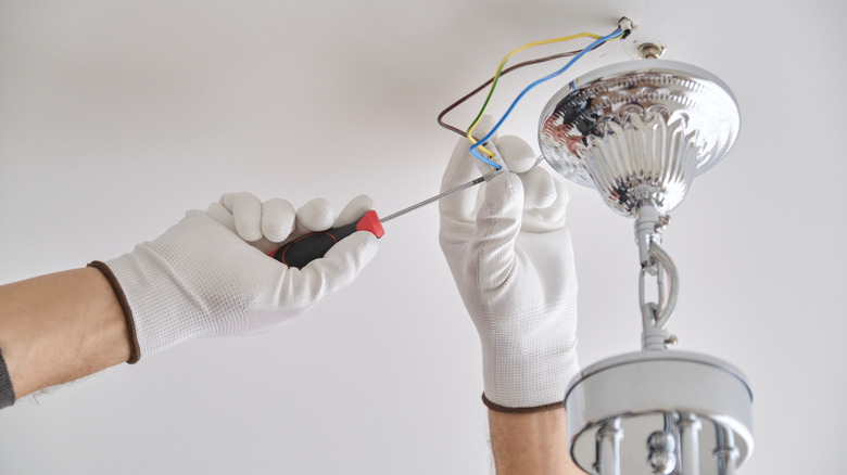 hands wiring chandelier