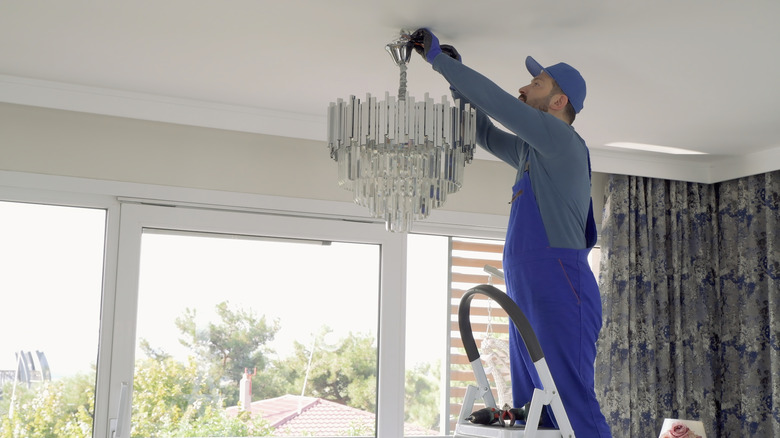 man hanging chandelier