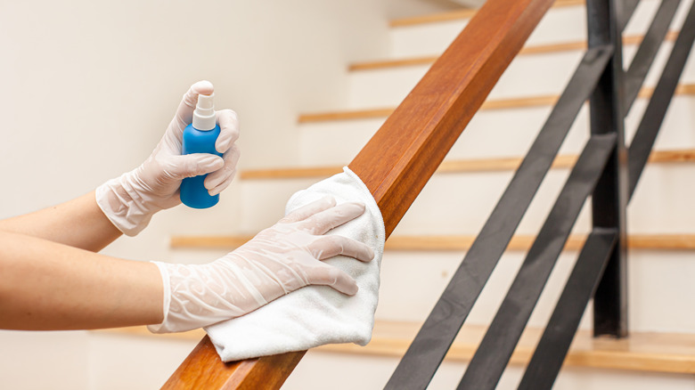 Person disinfecting stair banister