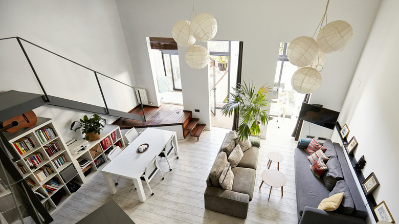 Open concept living room and dining with matching lights and a staircase