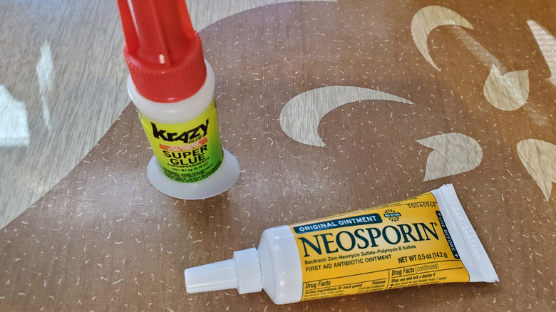 bottle of Krazy Glue and tube of Neosporin on tabletop