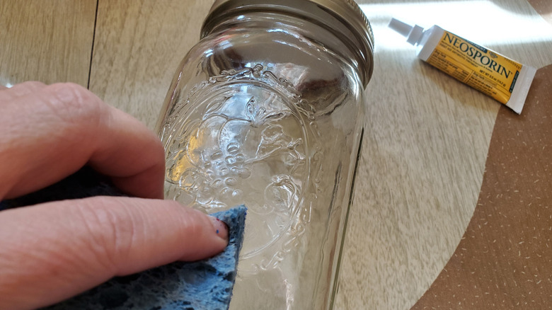 scrubbing dried glue on jar with neosporin and scouring pad