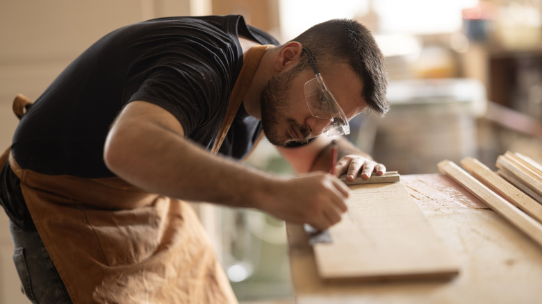 Carpenter measuring a plank of wood