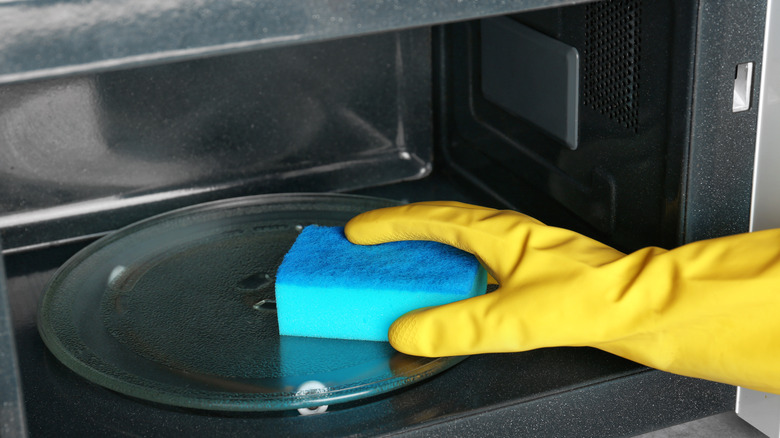 man's hand inside microwave