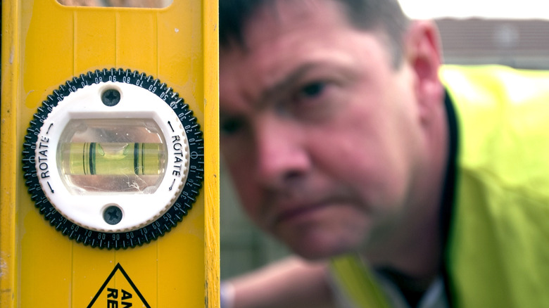 man looking at a bubble level