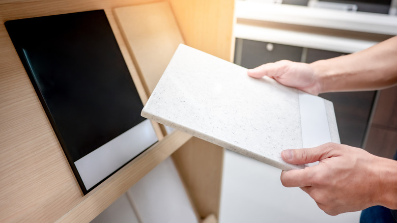 person holding up granite samples