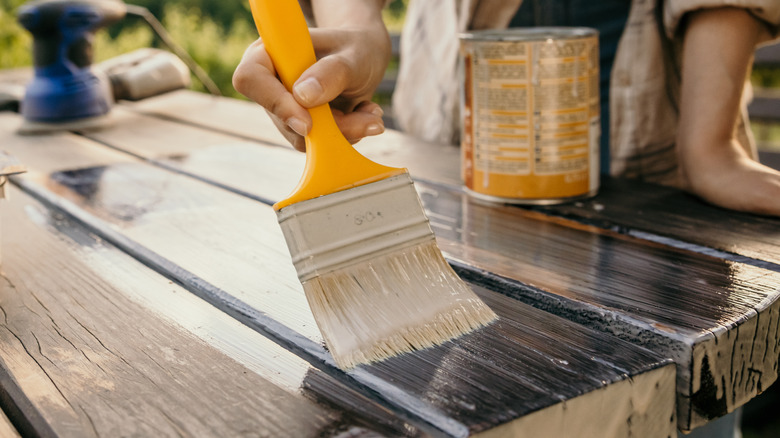 person painting wood pieces