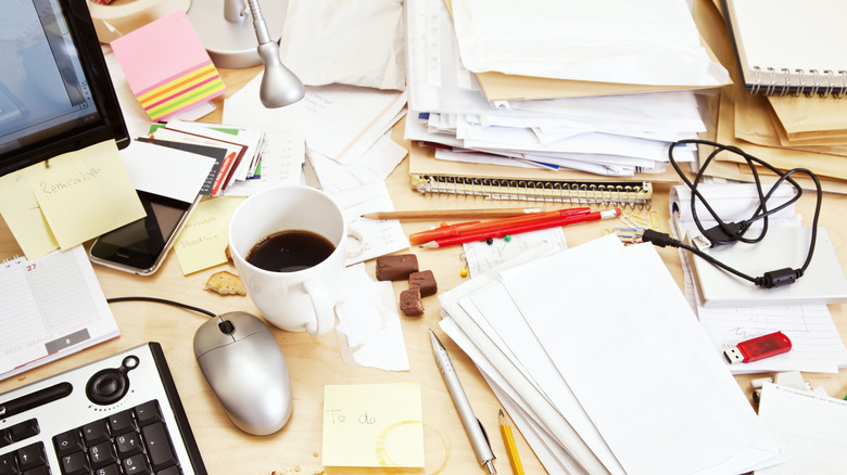 Paper clutter on desk with coffee stains