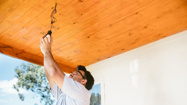 man working on porch ceiling