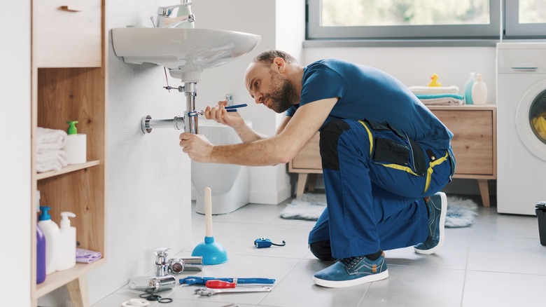 A plumber fixing a bathroom sink