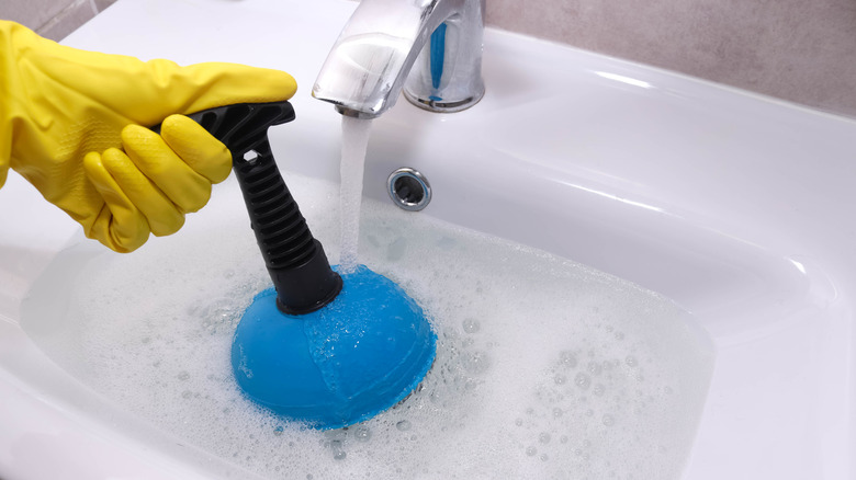 Unclogging a bathroom sink with a plunger